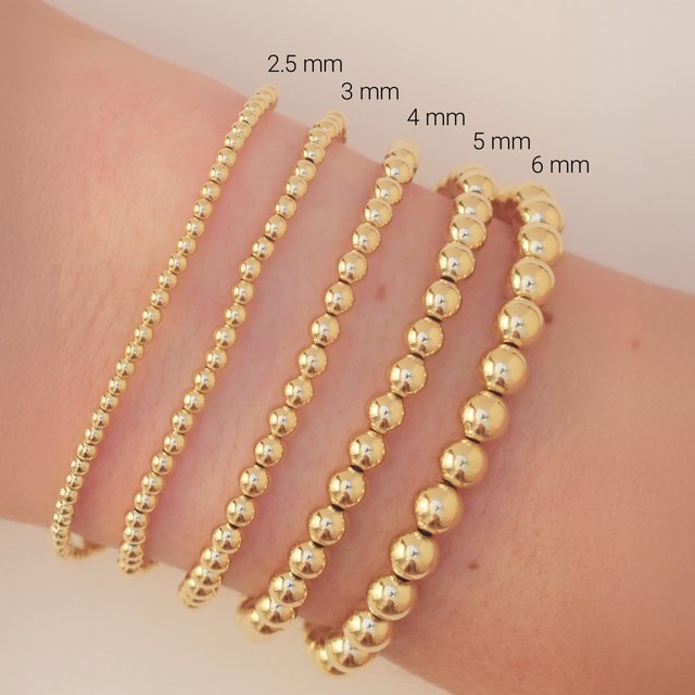 Comparison of gold filled bead sizes on wrist; ranging from delicate 2.5mm beads to bold 6mm beads for bracelet stacking